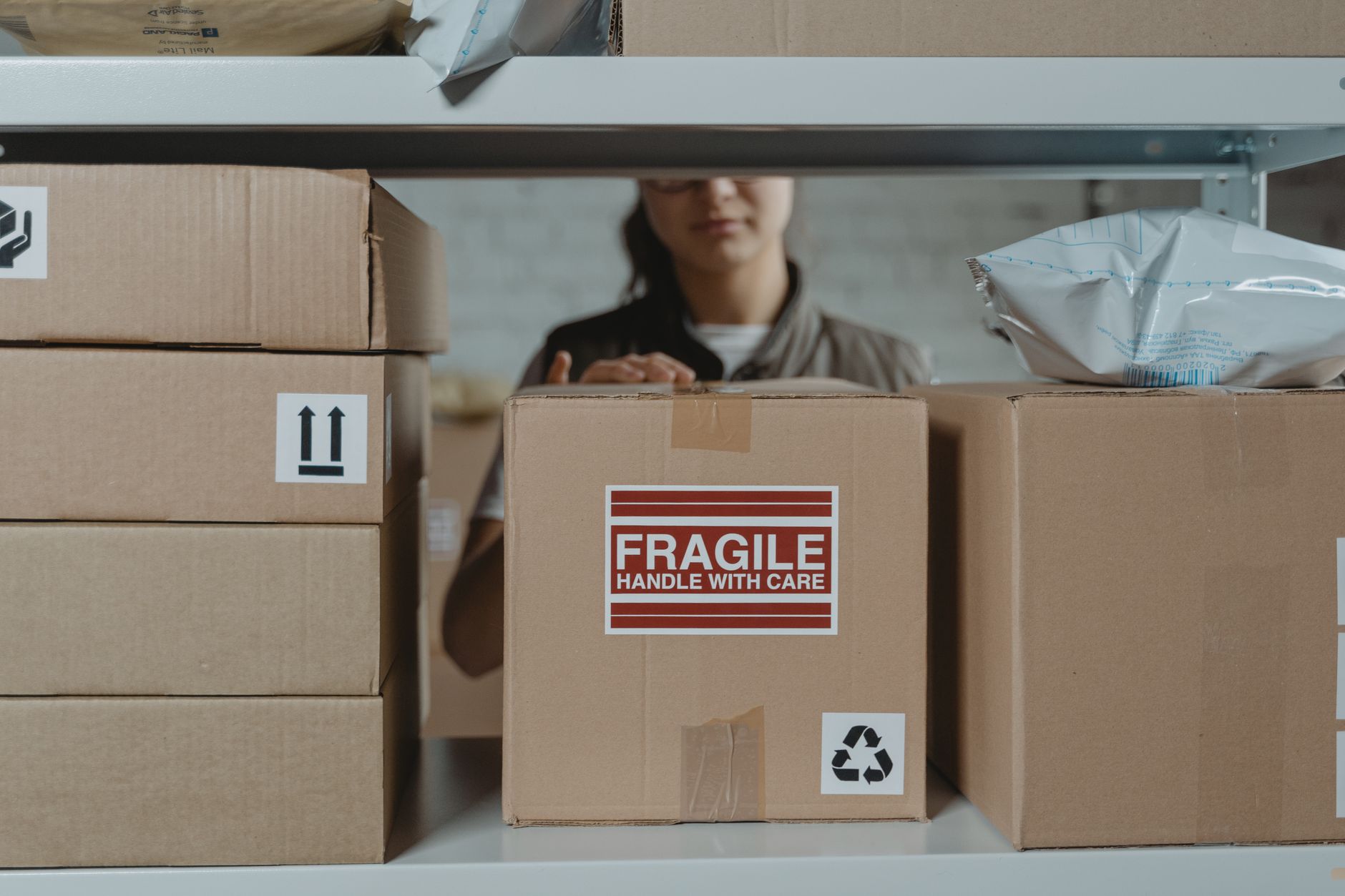 Amazon fulfillment center shelving with FBA labeled inventory boxes ready for pick pack and ship, illustrating how Fulfillment by Amazon works for beginner sellers in 2026